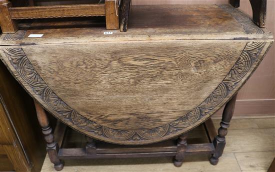 A 1920s carved oak gateleg table, W.104cm